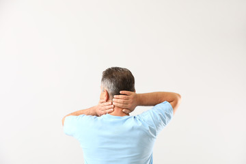 Mature man suffering from neck pain on white background