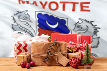 Mayotte new year celebration theme. Wrapped christmas gifts on waving national flag background. Merry christmas concept.