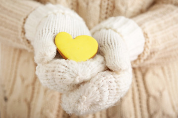 Fototapeta premium Woman in warm mittens and with tasty cookie, closeup