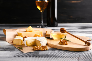 Assortment of fresh cheeses on wooden table