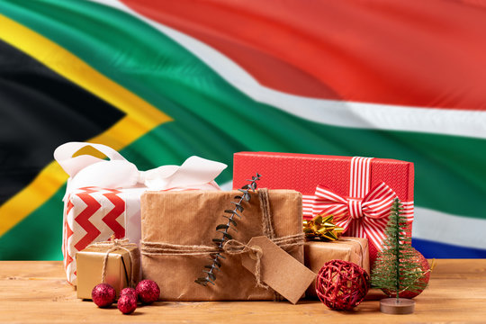 South Africa New Year Celebration Theme. Wrapped Christmas Gifts On Waving National Flag Background. Merry Christmas Concept.