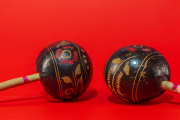 pair of handmade maracas isolated on red background. Latin and caribbean cultured and celebration...