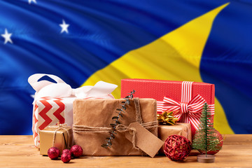 Tokelau new year celebration theme. Wrapped christmas gifts on waving national flag background. Merry christmas concept.
