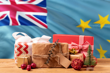 Tuvalu new year celebration theme. Wrapped christmas gifts on waving national flag background....