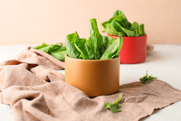 Bowl with fresh spinach on table