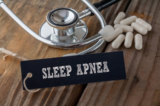 Sleep Arnea written on label tag with pills and Stethoscope on wood background
