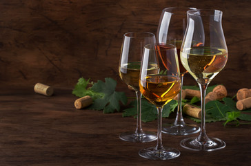 White wine set. Wine tasting, the most popular varieties of white wines in wine glasses on vintage wooden table in rustic style, selective focus