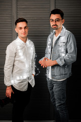 stylish guys in Christmas lights.Christmas decorations lights and highlights.two guys celebrate the new year