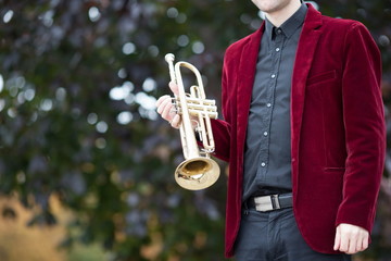 gold trumpet in hands of male musician in suit