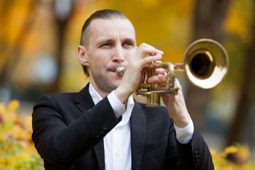 young trumpeter blowing his golden shiny trumpet