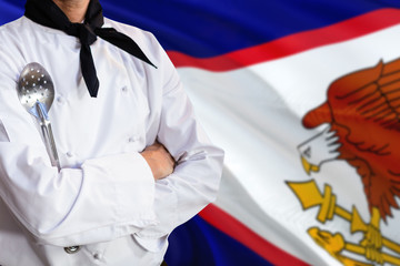 American Samoa domestic food concept. Professional chef in white uniform is standing with metal...