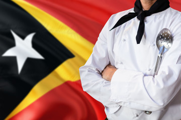 East Timor domestic food concept. Professional chef in white uniform is standing with metal spatula. Copy space for text.