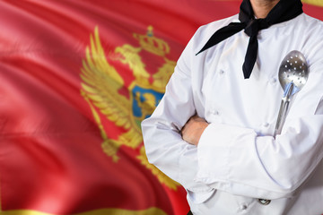 Montenegro domestic food concept. Professional chef in white uniform is standing with metal spatula. Copy space for text.