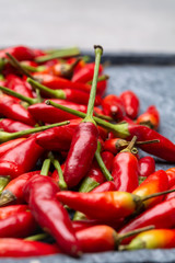 Fresh small red hot chili peppers on grey background