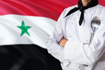 Syria domestic food concept. Professional chef in white uniform is standing with metal spatula. Copy space for text.