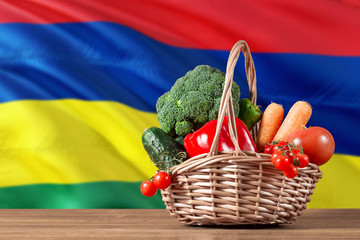 Mauritius organic food concept. National flag background with basket full of vegetables on wooden...