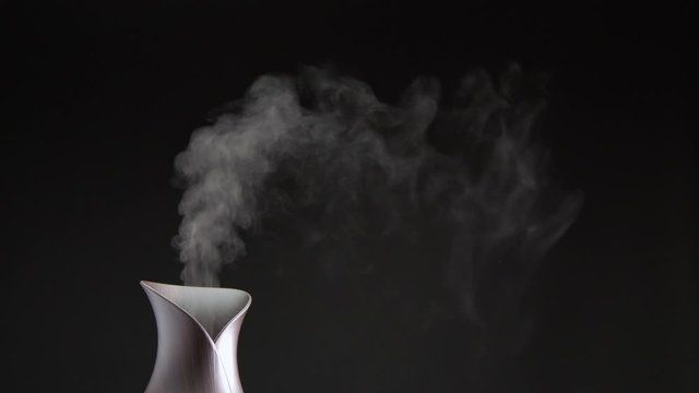 Cool mist machine in studio with a clear black background and room for copy.