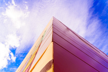 Intense blue sky with white clouds crossing an urban building.