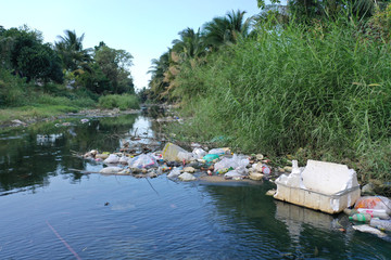 Water pollution. Raw sewage and plastic trash dumped in stream in poor slum village 