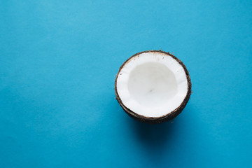 open coconut on blue background, copy space 