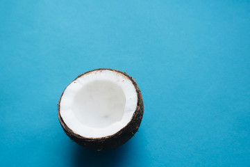 open coconut on blue background, copy space 