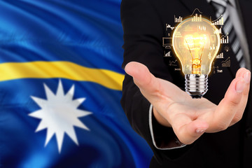 Nauru creativity concept. Businessman with a light bulb in his hand on national background....
