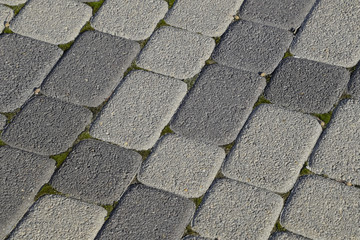 Industrial building background of paving slabs with overgrown wi