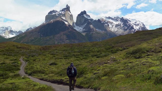 Hiker in Torres del Paine National Park in Chile with the iconic Cuernos del Paine mountains in the background, Patagonia, South America.