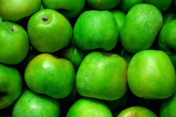 Green apples at market store background