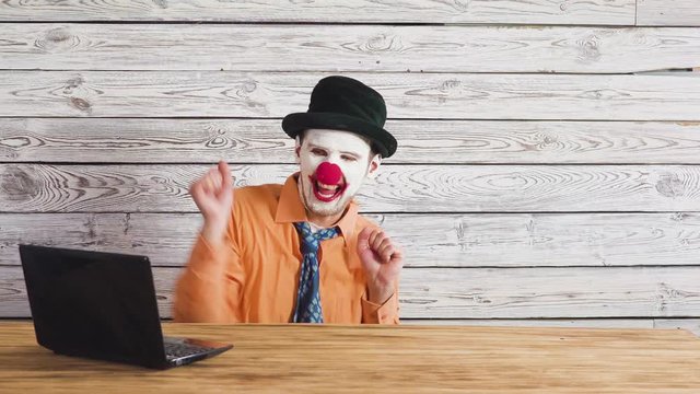 Office worker clown, clown concept at work. Businessman at the computer, work on a laptop.