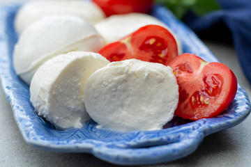 Cheese collection, fresh Italian soft mozzarella cheese in balls served with red ripe tomatoes