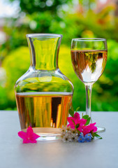 French rose wine served in garden in glass and carafe with colorful spring flowers