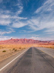 Fototapeta na wymiar The red rock formations of Danxia landform with empty highway in Xinjiang of China