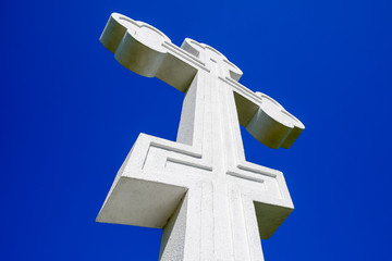 White orthodox christian cross on blue sky background.