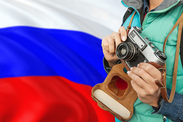 Russia photographer concept. Close-up adult woman holding retro camera on national flag background. Adventure and traveler theme.