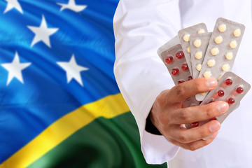 Solomon Islands pharmacy and medicine concept. Doctor holding pills tablet on national flag...