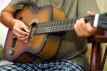 Hand  holding while playing acoustic guitar