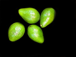  Lot of 4 large tropical avocados, on a black background