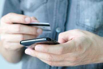 hand of young woman  in the living room using his computer and holding credit card her online To buy product in the internet