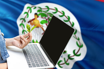 Belize modern agriculture concept. Farmers holding laptop, check tea on national flag background. Ecology theme with copy space.
