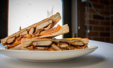 Close up image of chicken,cheese,ham bread toasts on a white plate. Two slices of breakfast toast bread.