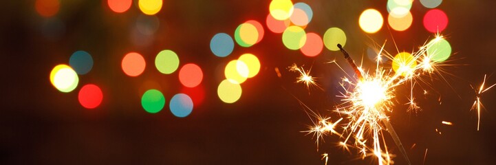 beautiful sparklers on the background of a garland. beautiful banner for the New Year.
