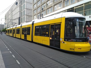 A beautiful yellow tram in the Alexanderplatz area of Berlin, Germany