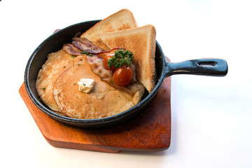 Top view image of Breakfast pancakes with bacon, butter and toast bread on white background.