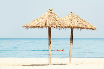 Fototapeta na wymiar Two tropical beach parasols facing the sea