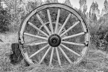 Fototapeta na wymiar Black and white image of an old wooden wagon wheel