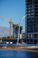 Ras al Khaimah building development building high rise hotel or apartment building complex with cranes and concrete on a beautiful blue sky day. Contruction concept.