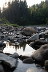 Stones at the shore of the forest river close-up, water