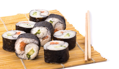 delicious Yin Yang sushi rolls on a Mat with sticks on a white background