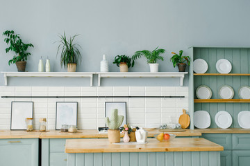 Scandinavian style in the kitchen interior in white and mint colors. White plates, houseplants